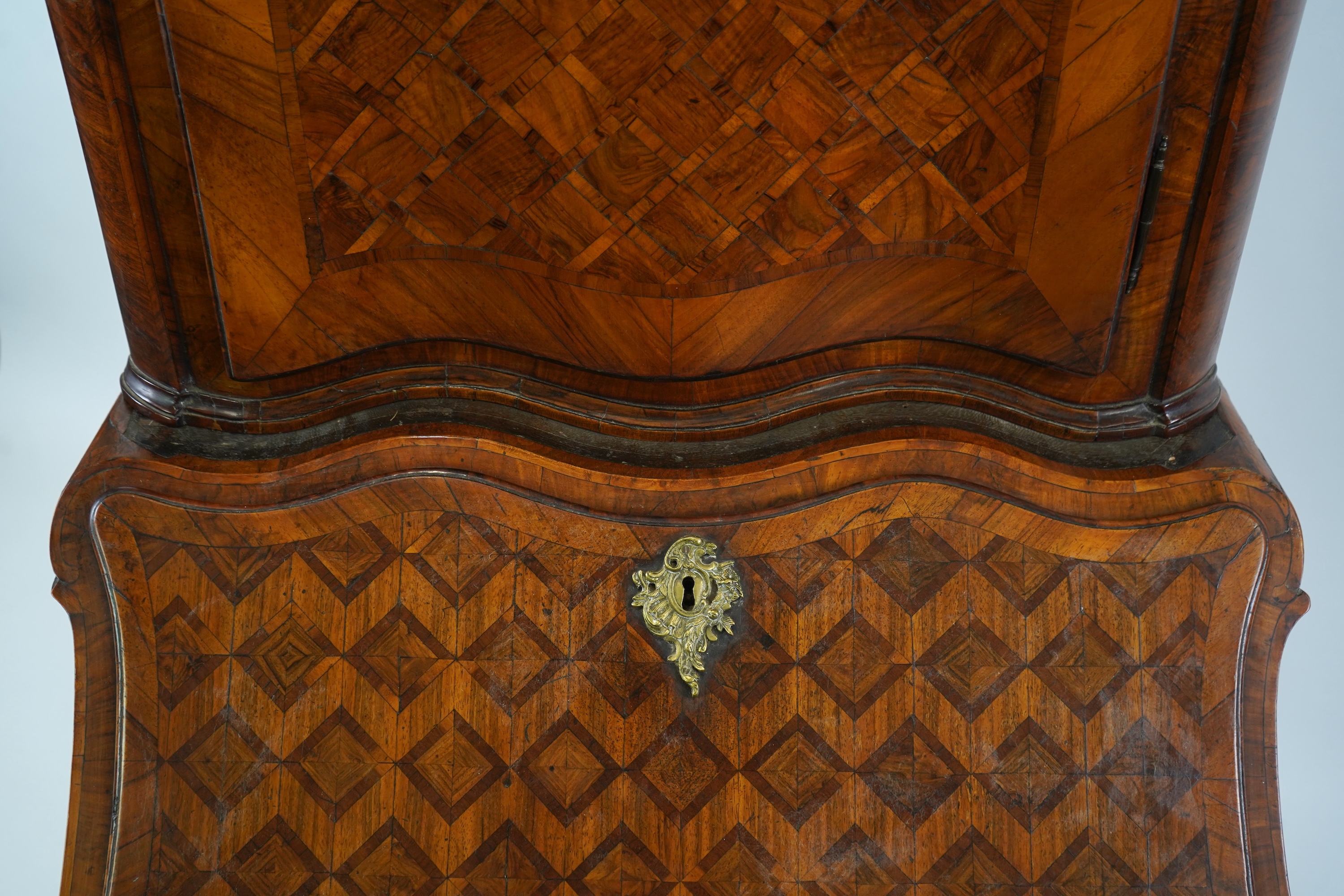 A mid 18th century North Italian or Maltese walnut and olive wood gilt metal mounted serpentine bureau cabinet